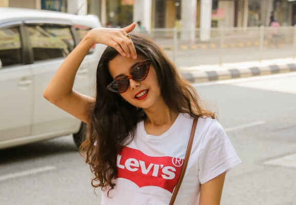 Γυναίκα φοράει λευκή μπλούζα με κόκκινη στάμπα Levi's