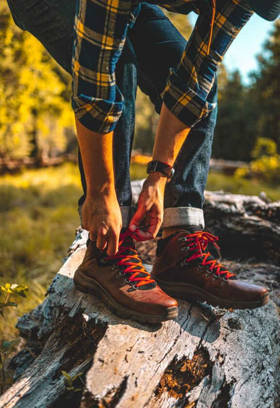 Άνδρας δένει τα κορδόνια του σε παπούτσια Timberland